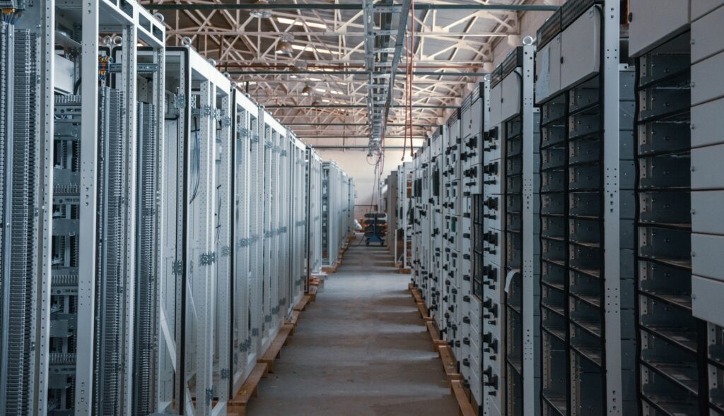 Halle mit zwei Reihen elektrischer Schaltanlagen – bei Batteriegroßspeichern entscheidet die Anschluss- und Umspanntechnik über den Wert des Standorts