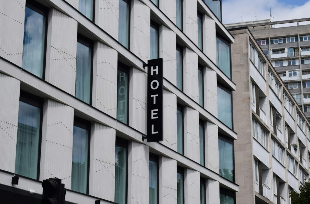 Fassade eines innerstädtischen Hotels mit vertikalem HOTEL-Schild – Hotelimmobilien bewerten Sachverständige über die nachhaltige Pachtfähigkeit des Betriebs