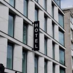 Fassade eines innerstädtischen Hotels mit vertikalem HOTEL-Schild – Hotelimmobilien bewerten Sachverständige über die nachhaltige Pachtfähigkeit des Betriebs