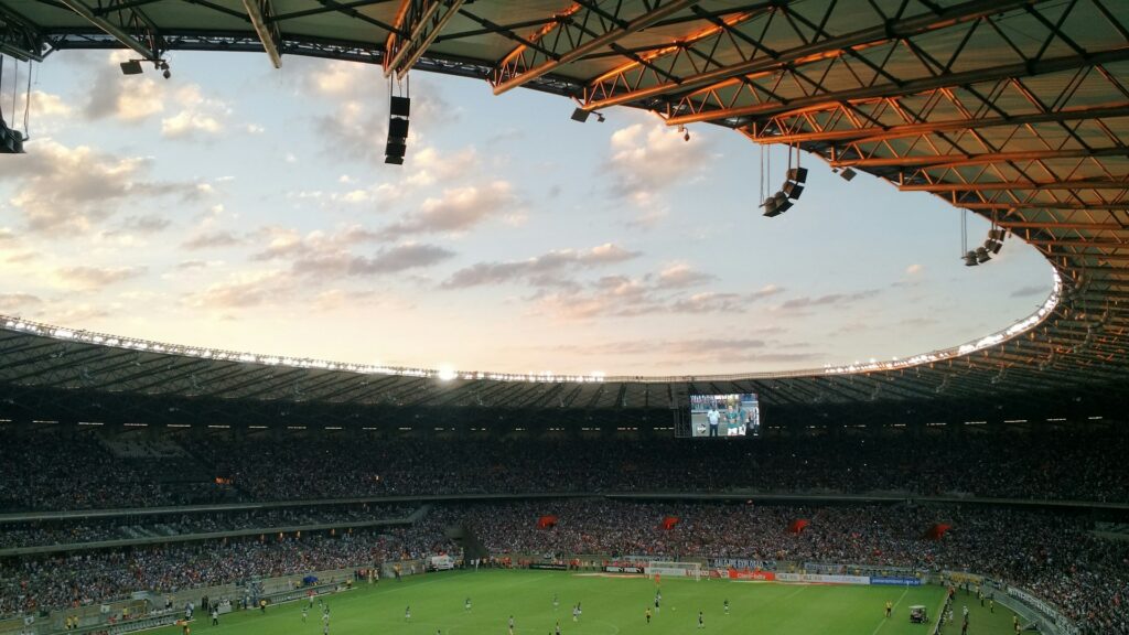 Gefüllte Multifunktionsarena im Abendlicht mit Blick über Ränge und Spielfeld