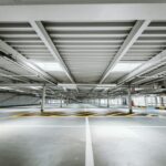 Leeres Parkdeck eines Parkhauses mit Fahrgassen, Stützen und Markierungen – bei Parkhäusern bestimmen Umschlag und Zustand der Fahrbahnplatten den Verkehrswert