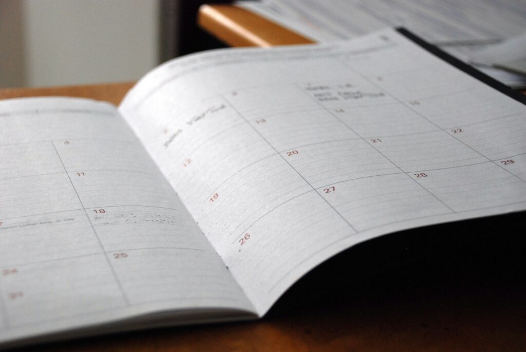Aufgeschlagener Terminkalender mit Monatsraster auf einem Schreibtisch – Sinnbild für Qualitätsstichtag und Wertermittlungsstichtag in der Immobilienbewertung